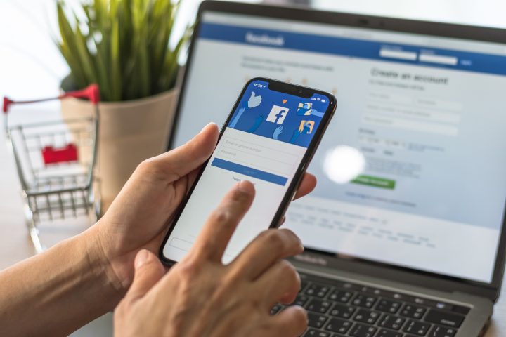 BANGKOK, THAILAND - May 2, 2018: Facebook social media app logo on log-in, sign-up registration page on mobile app screen on iPhone X (10) in person's hand working on e-commerce shopping business
